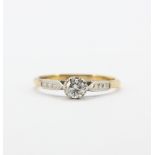 An 18ct yellow and white gold solitaire ring set with an old cut diamond, (Q.5).