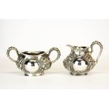 A sterling silver sugar bowl and milk jug with hammered Art Nouveau design, stamped Sterling 925/