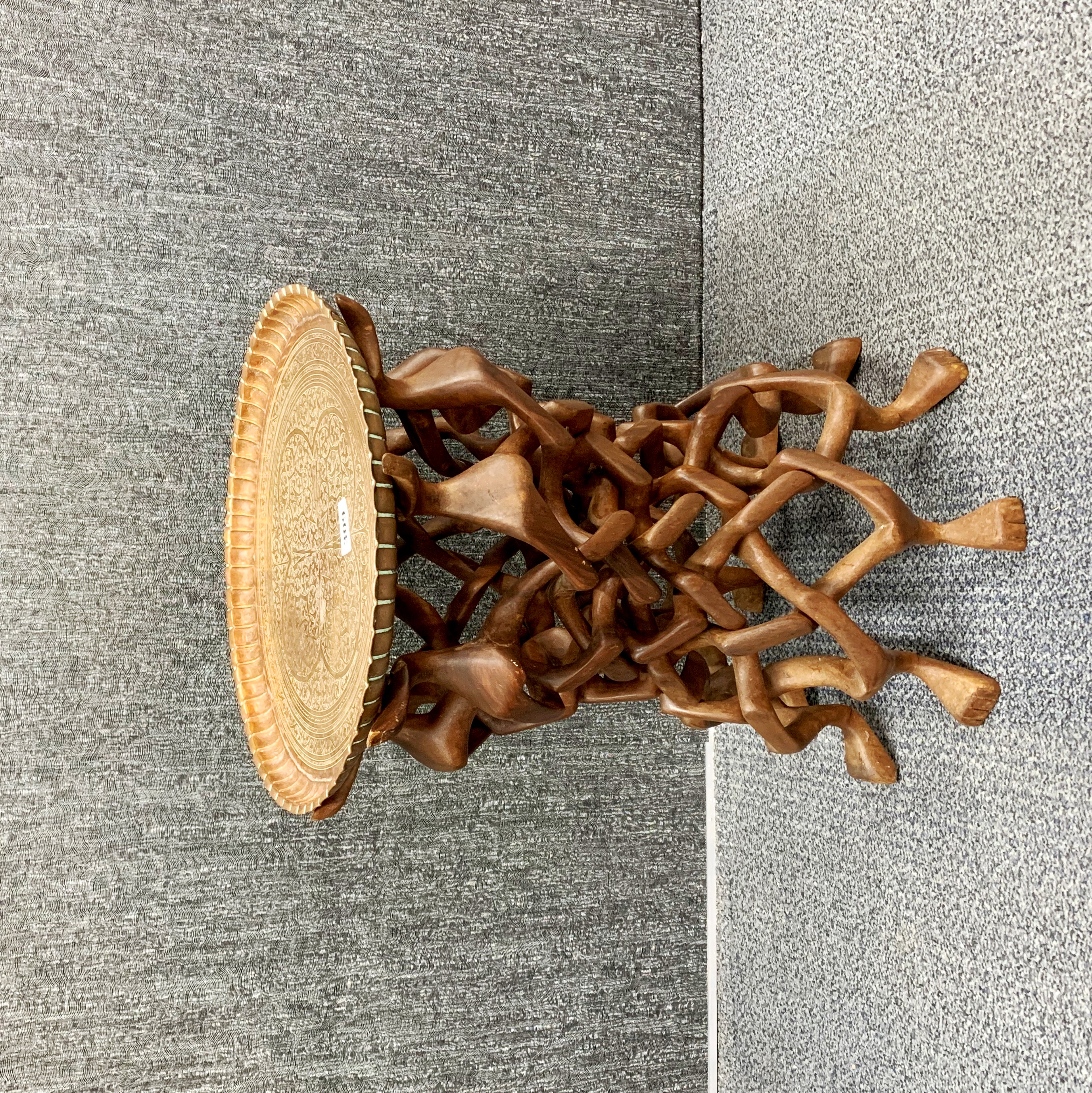 An unusual Eastern hardwood puzzle table, carved from a single piece of wood with an engraved copper