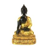 A Tibetan gilt bronze figure of a seated Buddha, H. 23cm.