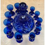 A Bohemian cut crystal decanter, H. 28cm, with a group of twelve blue glasses.