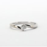 An 18ct white gold (stamped 750) brilliant cut diamond set solitaire ring, (O).