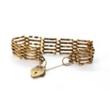 A 9ct yellow gold gate bracelet with heart shaped clasp, L. 15cm.