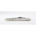 A 14ct white gold (stamped 14k) tennis bracelet set with brilliant cut diamonds, approx. 12.06ct, L.