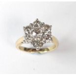 A 18ct yellow gold flower style cluster ring set with diamonds in a claw setting with the center