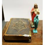 A large Victorian brass bound leather bible and two religious figures.