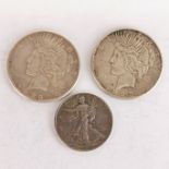 A 1922 and 1923 silver one dollar coins and a 1940 half dollar.