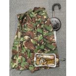 A military camoflage uniform with various military related used ammunition.