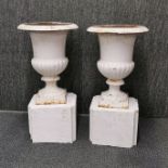 A pair of vintage painted cast iron garden urns on concrete pedestals, H. 61cm.