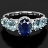 A 925 silver ring set with an oval cut sapphire and blue topaz set shoulders, (P.5).