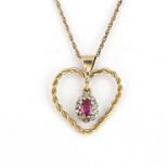 A yellow metal heart shaped pendant set with an oval cut red stone surrounded by diamonds on a 9ct