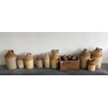 A wooden bottle crate and a group stoneware flagons, tallest H. 43cm.