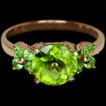 A 925 silver rose gold gilt ring set with peridot and tsavorite set shoulders, (N).