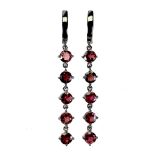 A pair of 925 silver rhodium plated drop earrings set with round cut garnets, L. 5.5cm.