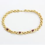 An 18ct yellow gold bracelet set with oval cut rubies and diamonds, L. 19cm.