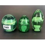 Three early English bottle glass dump paperweights, tallest H. 11cm.