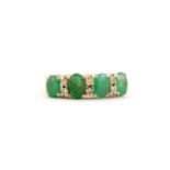 An 18ct yellow gold (marked 18K) ring set with large oval cut emeralds and diamonds, (O.5).