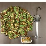 A military camoflage uniform with various military related used ammunition.