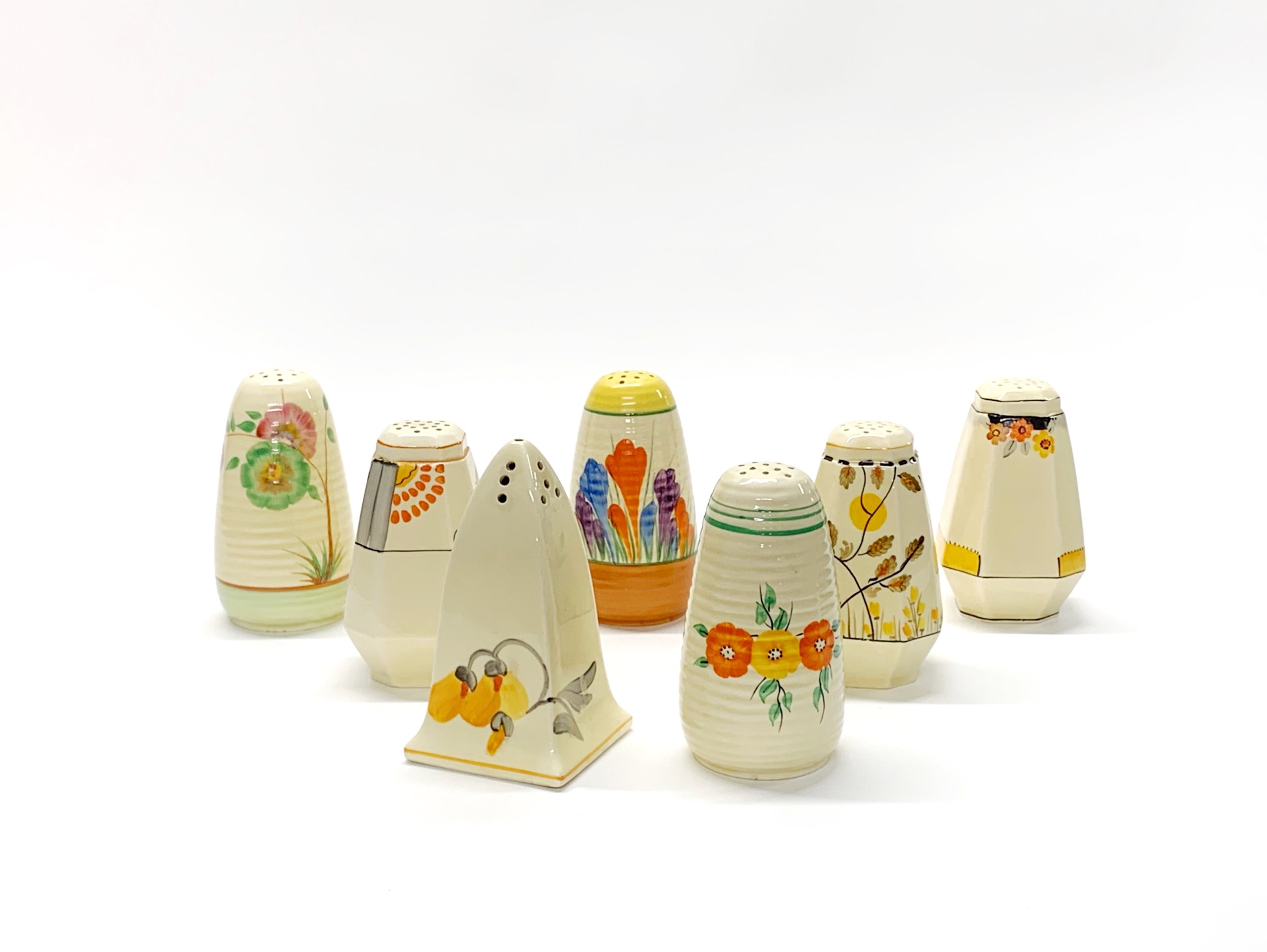 A group of Clarice Cliff, Crown Devon and other Art Deco sugar shakers, H. 12cm.