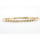 A hallmarked 9ct yellow gold bangle set with brilliant cut diamonds, approx. 0.50ct total, colour H,