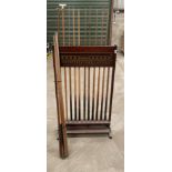 A vintage rack of snooker cues with a collection of additional cues, rack H. 129cm.