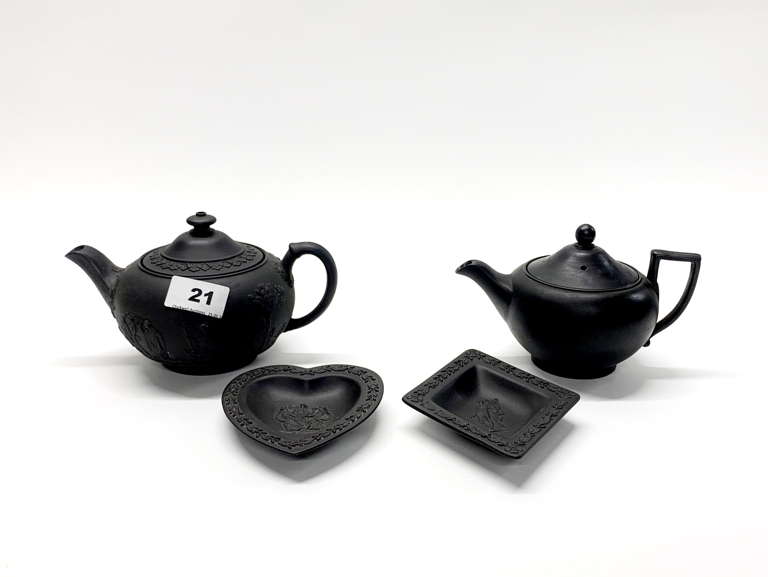 Two Wedgwood Black Basalt teapots, c. 1900, together with two Black Basalt dishes.