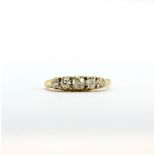 A yellow metal (tested high carat gold) ring set with five graduated old cut diamonds, approx. 0.