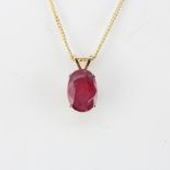 A yellow metal pendant (tested minimum 9ct gold) set with a large oval cut ruby L. 1.5cm, on a 9ct