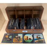 A collection of early glass lantern slides in a mahogany case depicting various subjects.