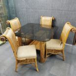 A five piece cane and iron conservatory table with a smoked glass top with a matching armchair and