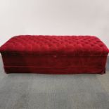 A large storage footstool/ seat with buttoned red upholstery, 170 x 73 x 45cm.