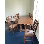 A large oak refectory table with a set of eight ladder back chairs with leather upholstery, 215 x