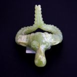 A Chinese carved celadon green nephrite jade rams head amulet, W. 8cm, L. 8cm, together with a