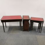 A mahogany leather topped table containing a set of stainless steel cutlery together with a