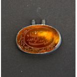 Islamic interest: A small white metal mounted engraved agate amulet, W. 3cm.