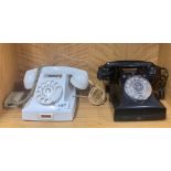An early white Bakelite telephone with a black Bakelite telephone.