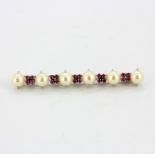 An 18ct white gold bar brooch set with cultured pearls and round cut rubies, L. 5.5cm.