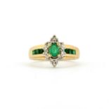 A 14ct yellow gold (stamped 14K) cluster ring set with an oval cut emeralds surrounded by diamonds