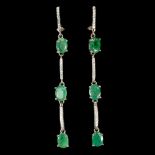 A pair of long 925 silver drop earrings set with oval cut emeralds and white stones, L. 6.2cm.