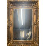 A large gilt framed bevelled glass mirror, frame size 98 x 128cm.