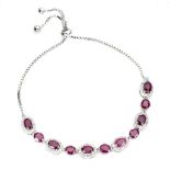 A 925 silver adjustable bracelet set with oval cut rubies and white stones.