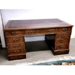 An oxblood leather topped gentleman's mahogany desk, 153 x 92cm (two handles missing).