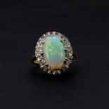 A hallmarked 18ct yellow and white gold ring set with a large oval cabochon cut opal, opal size 1.