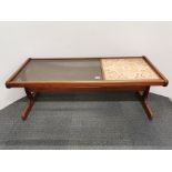 A 1970's tiled and smoked glass topped teak coffee table, 121 x 49 x 45cm.