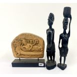 A carved stone relief panel, H. 24cm, together with two carved ebony figures.