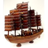 A large Chinese handmade wooden model of a sailing junk, L. 80cm, H. 75cm.