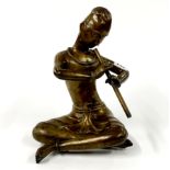A Himalayan bronze figure of a monk playing a flute, H. 31cm.