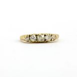 A yellow metal (tested high carat gold) ring set with five graduated old cut diamonds, approx. 0.