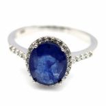 A 925 silver cluster ring set with oval cut sapphire and white stones, (P).
