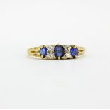 An 18ct yellow gold ring set with oval cut sapphires and diamonds, (O).